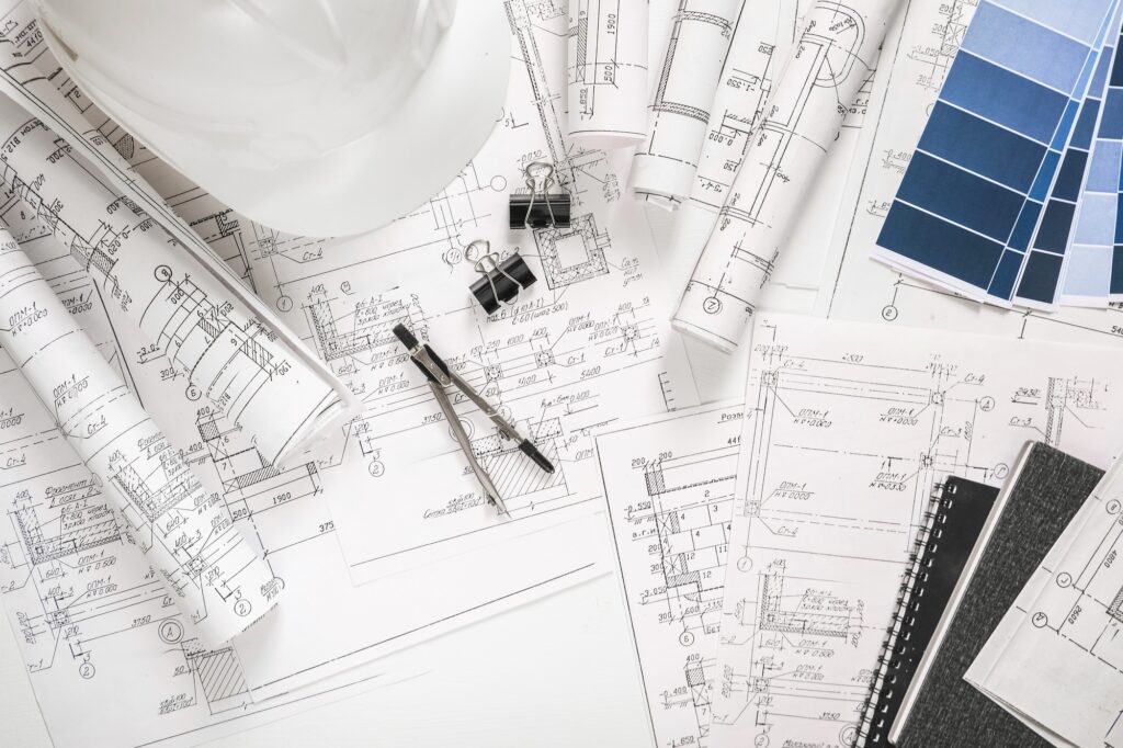 Blueprints and tools arranged for detailed construction site drawing and project planning.